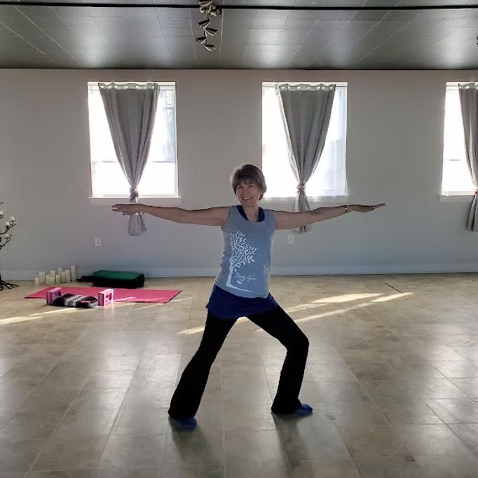 An instructor demonstrating a yoga pose in the community center